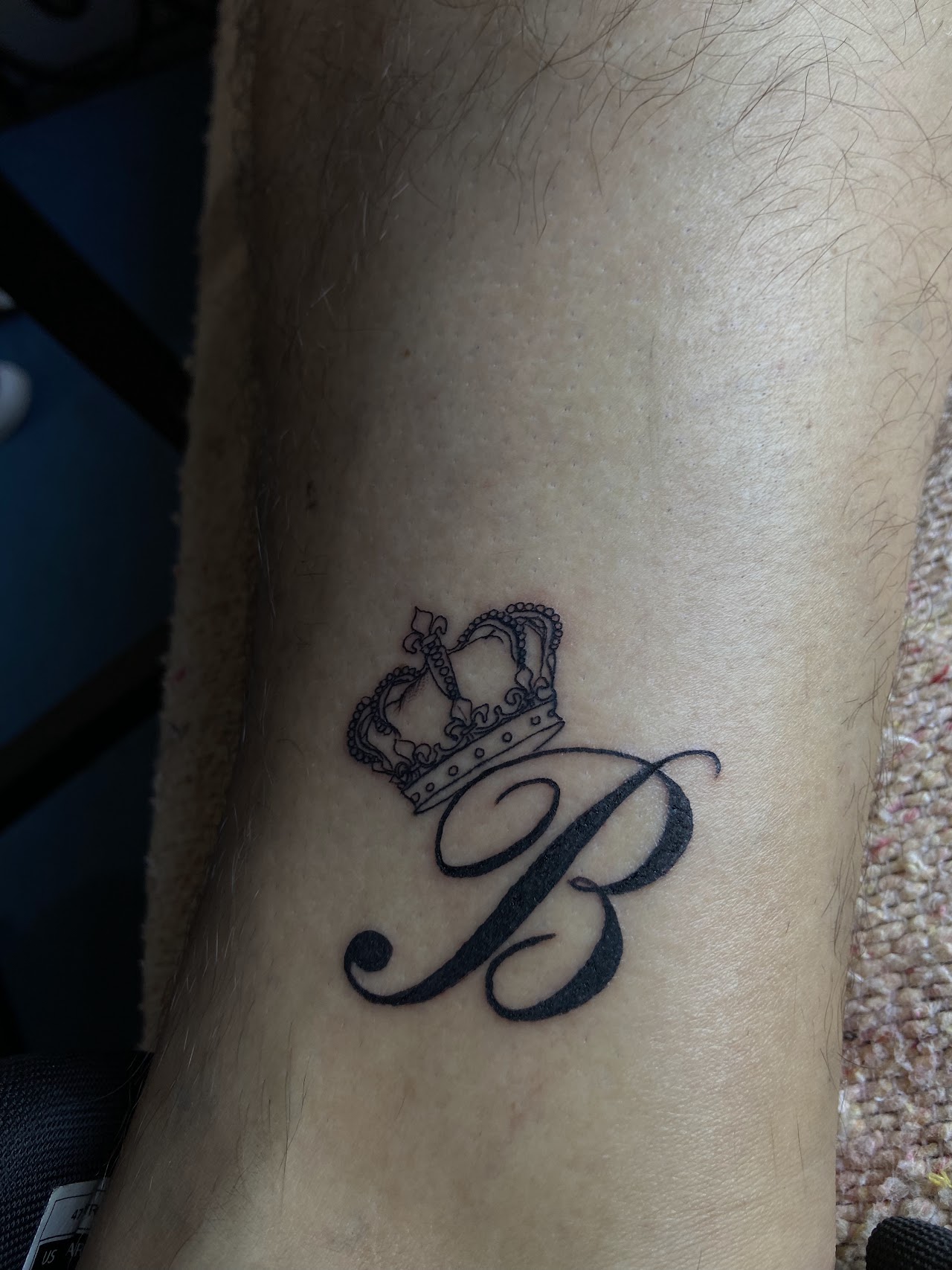Tatuaje de corona y letra hecho en GEMINISS TATTOO